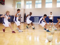 Students run on a basketball court in PE class