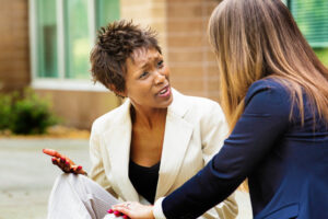 Two woman teachers arguing outside school