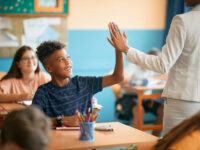 teacher high fiving student in classroom