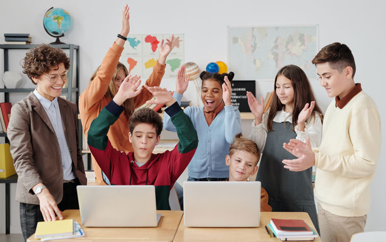 students celebrating around computer